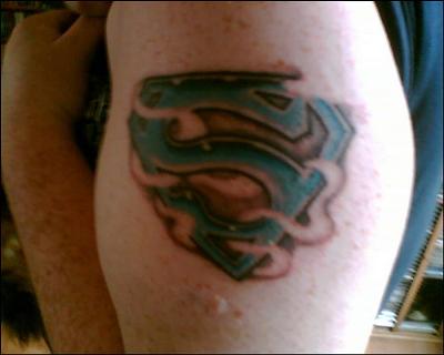 My Superman emblem tattoo is inked on my bicep in blue ink surrounded with 
