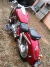 Side view of a 2002 Honda VTX1800 Cruiser with a dark red paint color